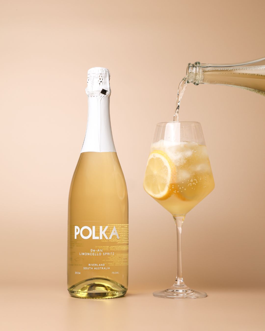 polka non alcoholic limoncello spritz pouring into glass on plain background