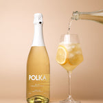 polka non alcoholic limoncello spritz pouring into glass on plain background